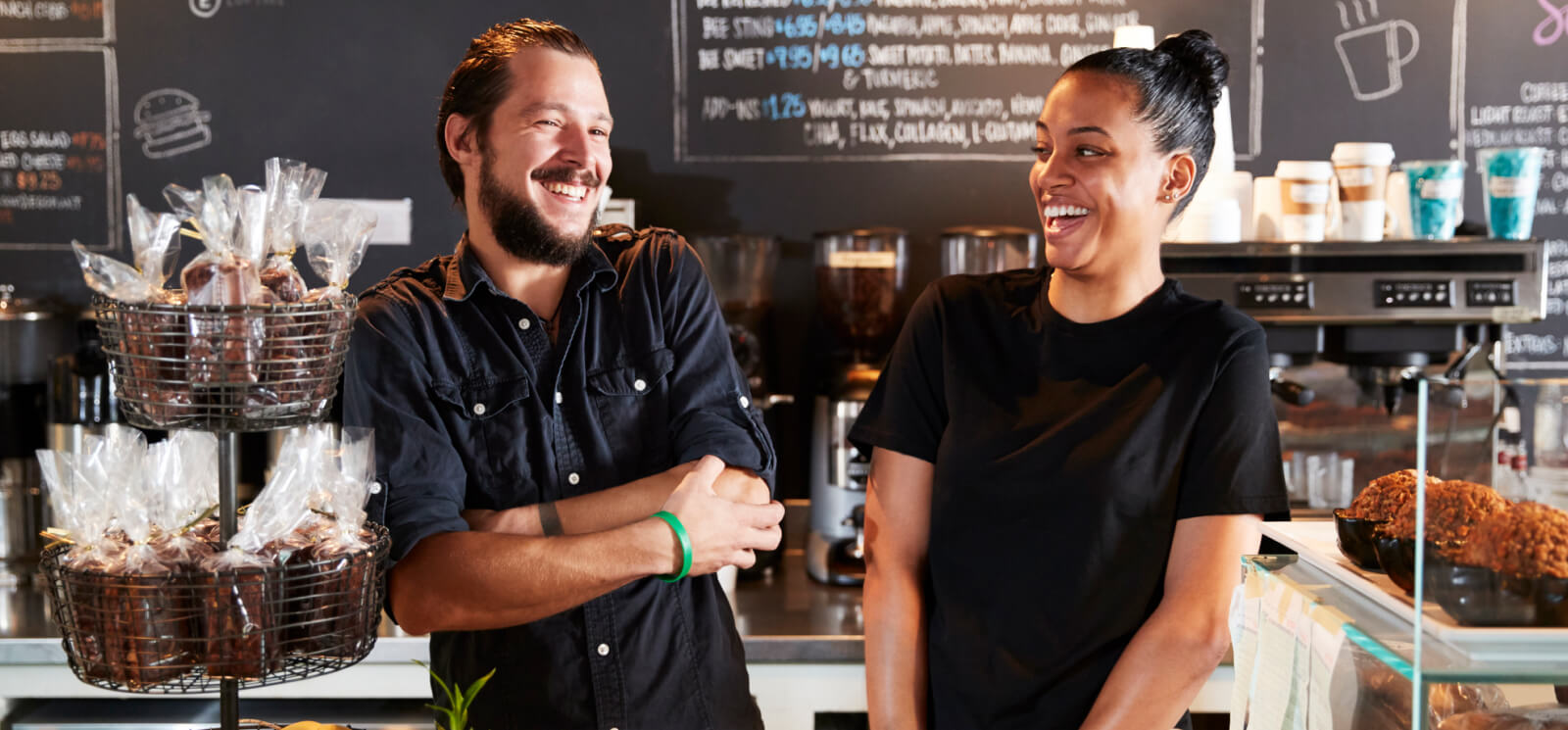 Two workers at a cafe laughing