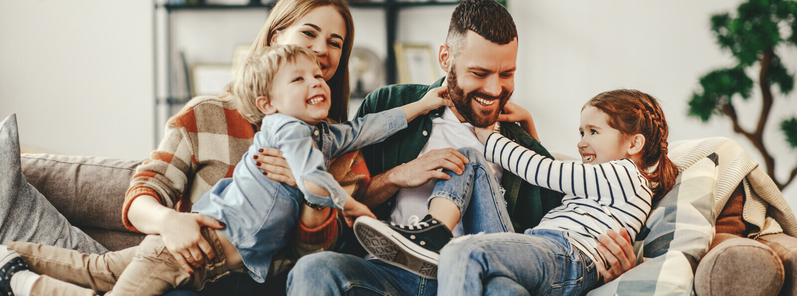 A young family playing on a couch