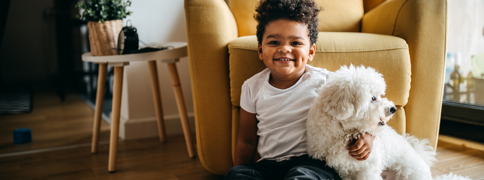 A toddler hugging a small dog