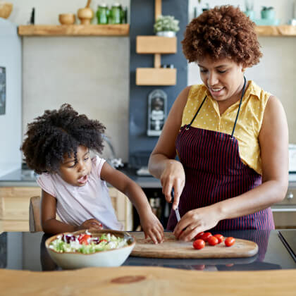 A mom and kid cooking with vegetables
