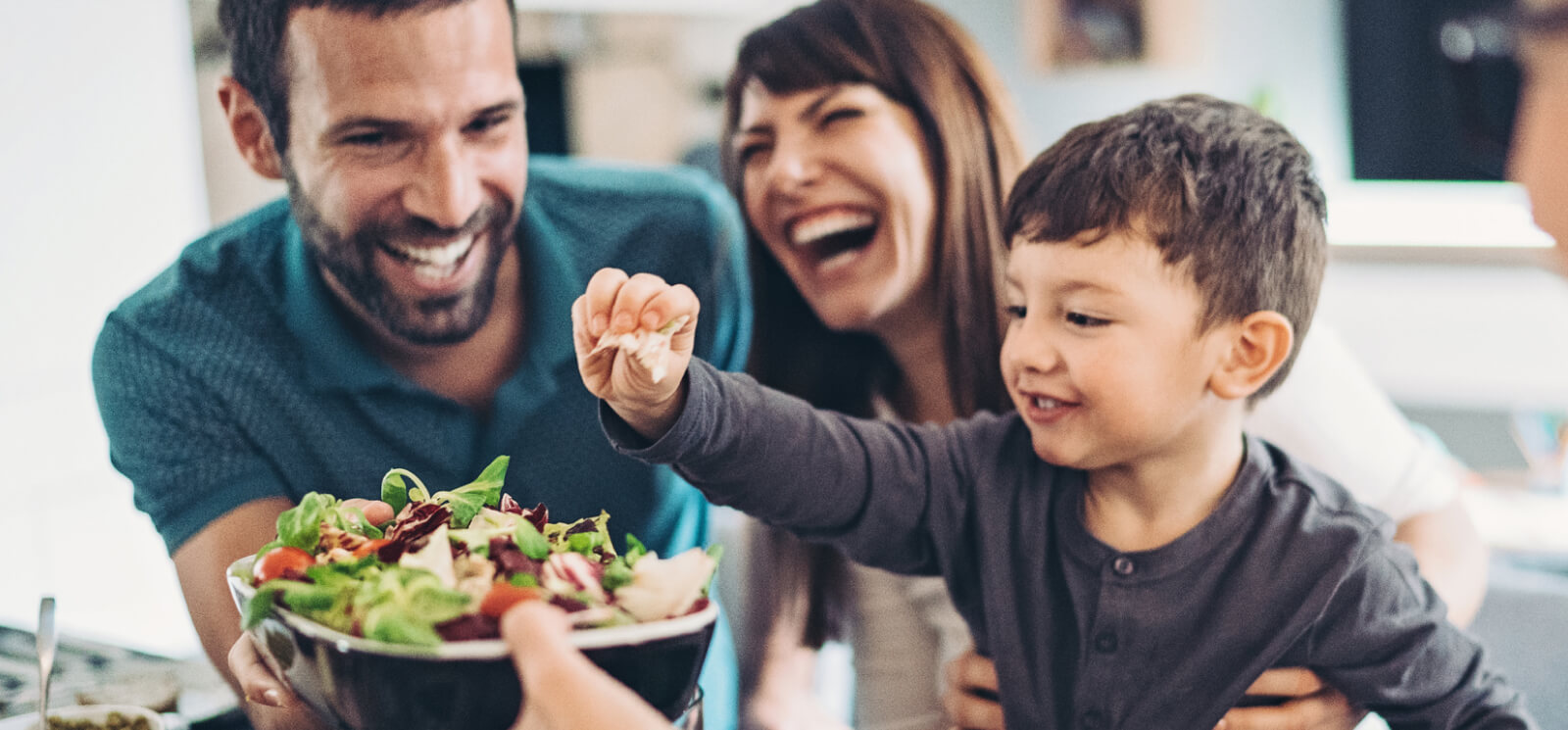 A young family passing around food at a table